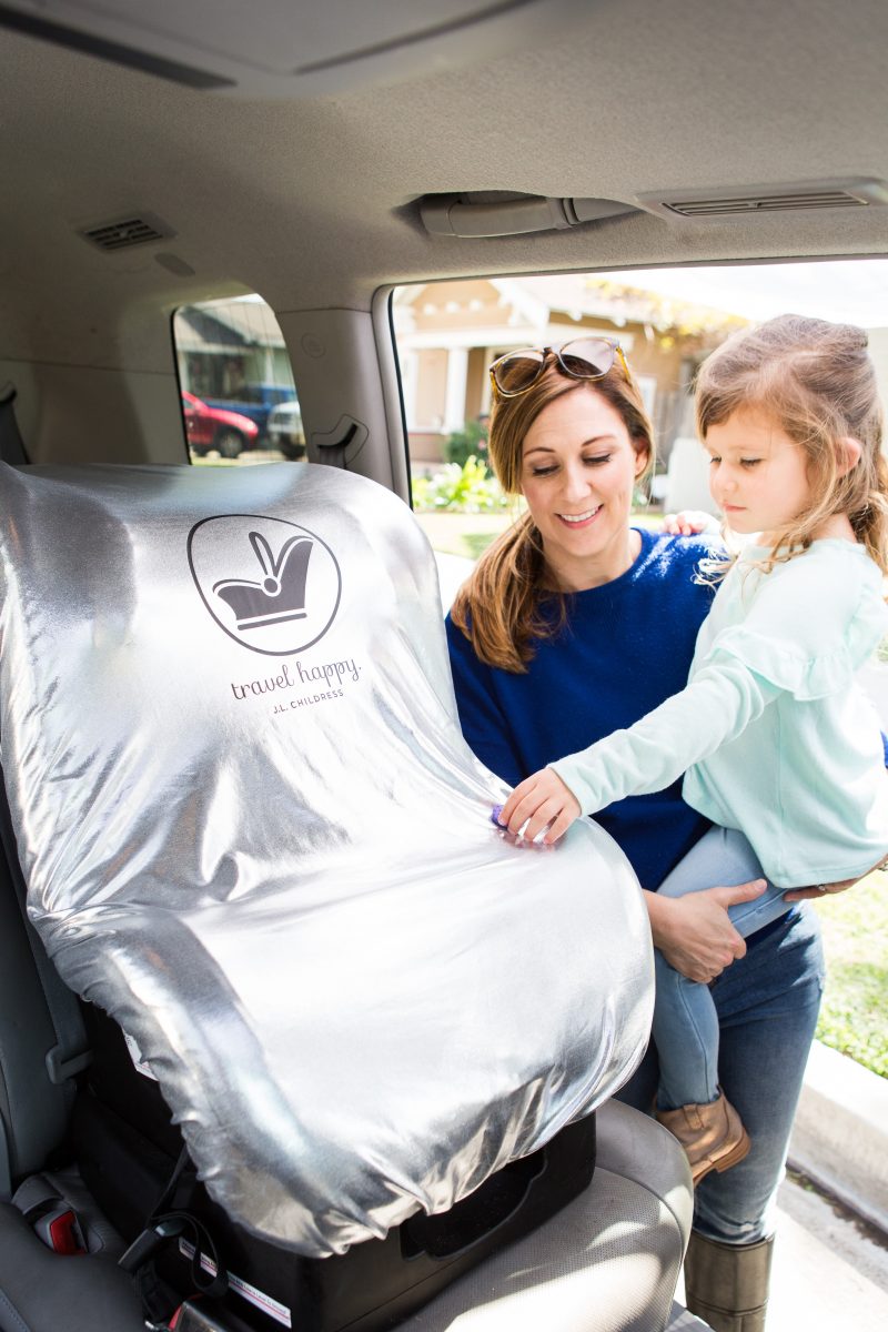 Woman putting the Cool 'N Cover Car Seat Heat Shield and Sun Shade on a car seat in the vehicle