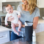 Woman holding baby with the All Bottle Cooler, black sitting on counter