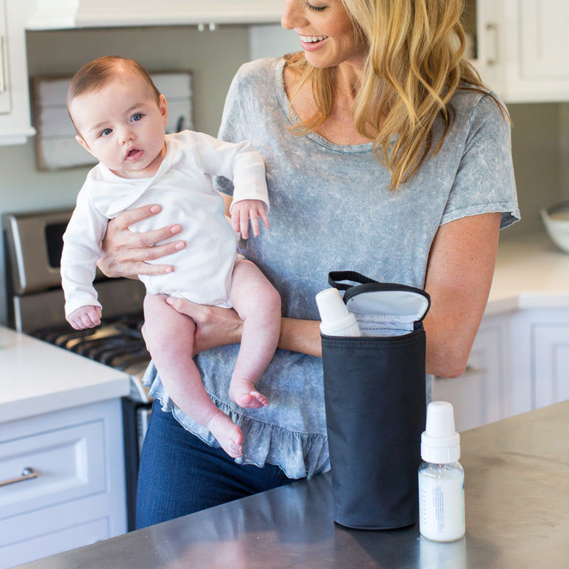 Woman holding baby with the All Bottle Cooler, black sitting on counter