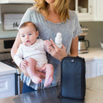 Woman holding baby with Pack ‘N Protect Cooler Bag for Glass Bottles and Containers sitting on counter