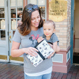 Woman holding baby and Disney Baby Full Body Changing Pad Mickey Minnie Ivory folded