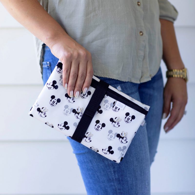 woman holding Disney Baby Full Body Changing Pad Mickey Minnie Ivory folded