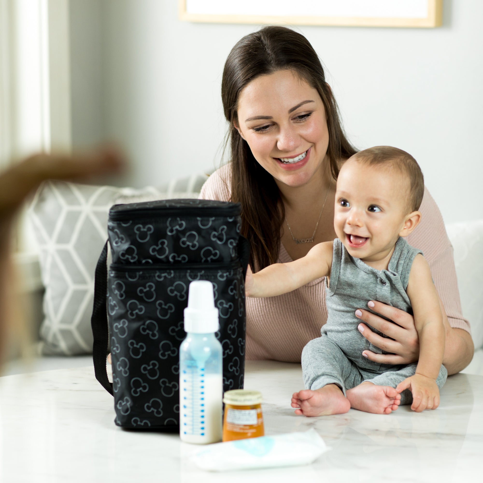 Woman and baby sitting at table with Disney Baby 6 Bottle Cooler, Mickey Black