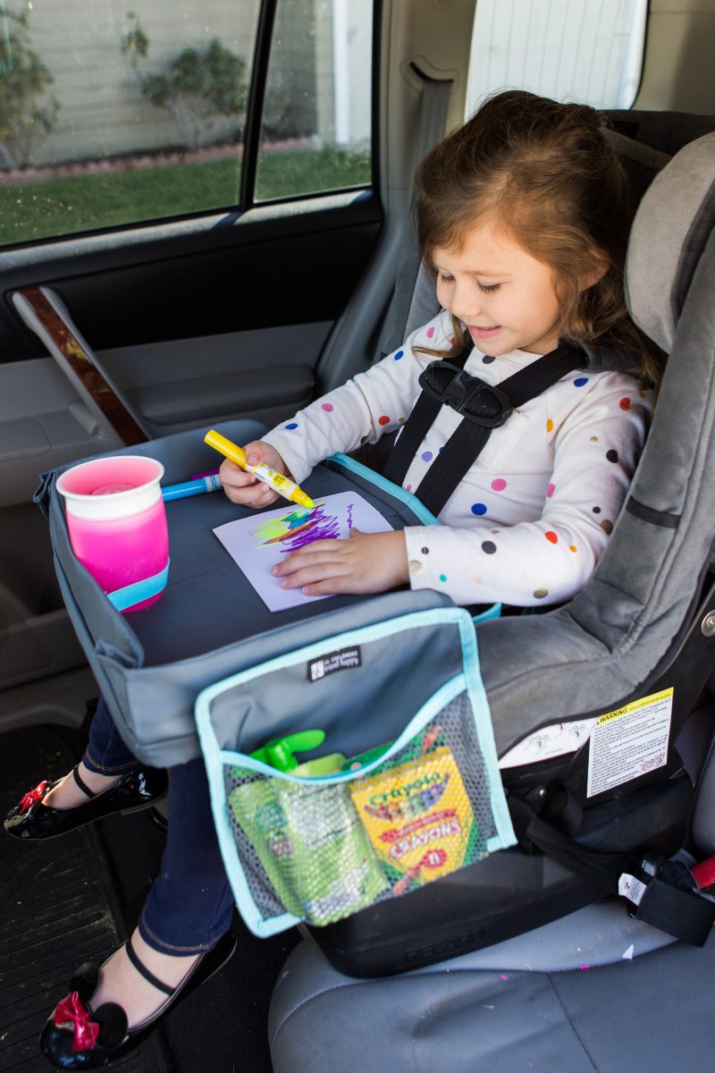 Child sitting in car seat and drawing with the 3-IN-1 Travel Tray and Tablet Holder