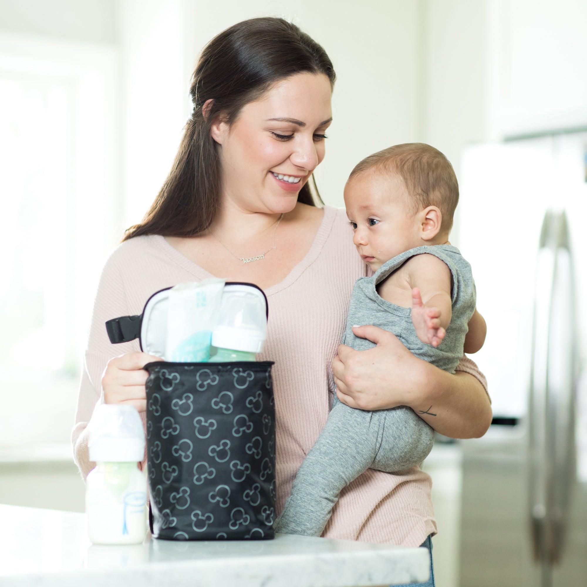 Woman and baby standing next to counter with Disney Baby TwoCOOL Double Bottle Cooler, Mickey Black on it
