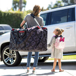Woman walking with child holding the Disney Baby Single & Double Stroller Travel Bag, Mickey Black