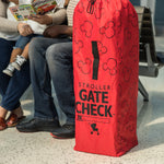 Family sitting next to the Disney Baby Gate Check Travel Bag for Umbrella Strollers